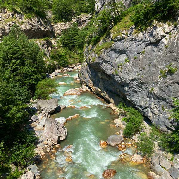 A close-up of the river in Bogë, Kosovo, showing its clear waters and lush surroundings.