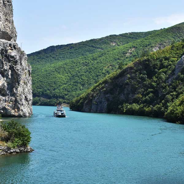 A boat floating in koman lake in the Albanian wilderness.