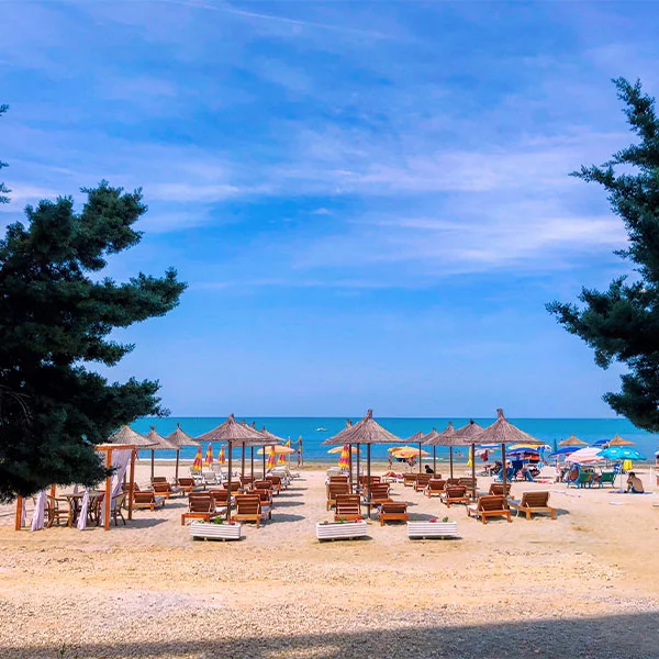 Sandy beach in Durrës, Albania, along the Adriatic Sea under a clear blue sky.