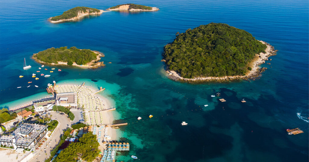 An aerial view of Ksamil Beach, with boats and islands in the distance.