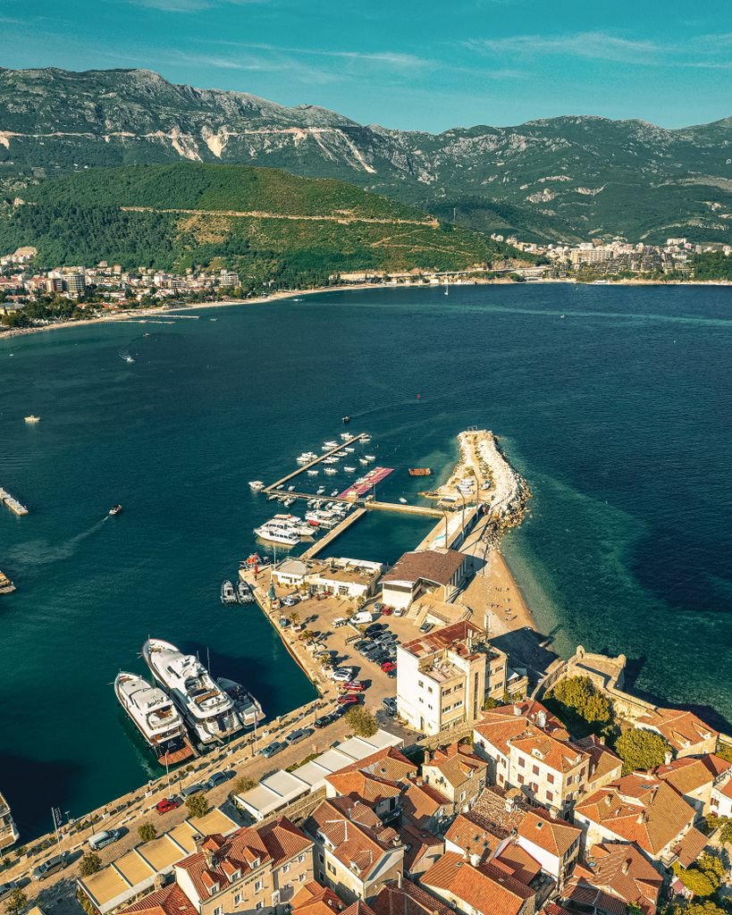 Photo by Alexander Nadrilyanski Aerial view of Budva's marina and coastline, showcasing scenic landscapes and vibrant town life.