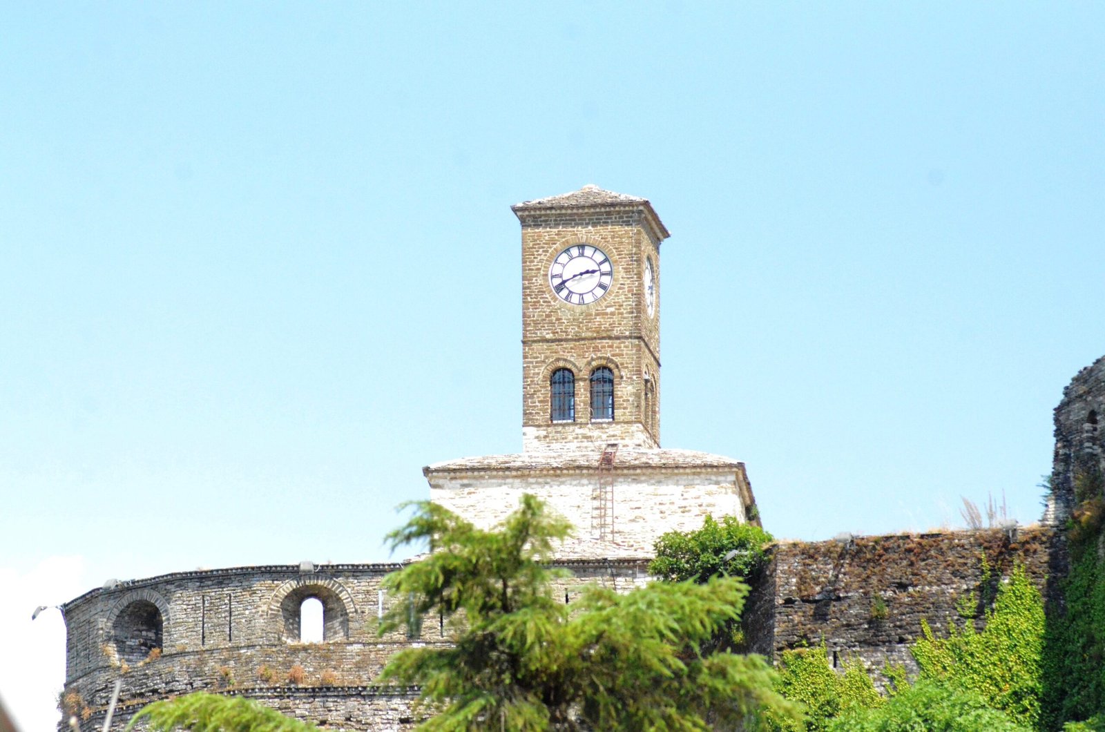 Clock tower at Gjirokastra Castle overlooking the historic city and surrounding mountains in Albania.