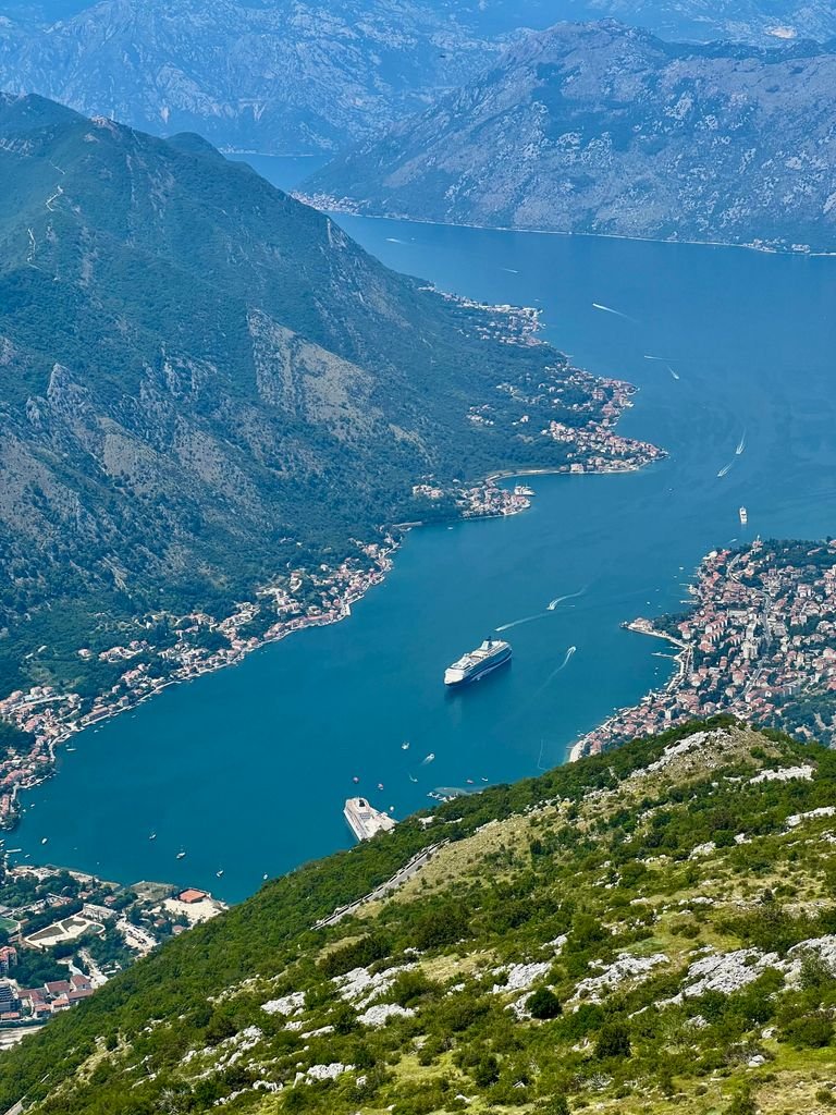 Aerial View of the Bay of Kotor, Montenegro Aerial view of a cruise ship sailing through the Bay of Kotor, surrounded by Montenegro's mountains